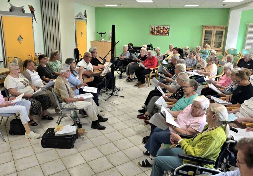 BewohnerInnen singen von Liedblättern mit beim CSU-Singen
