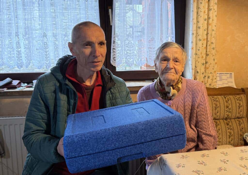 Der Fahrer liefert das Mittagessen in einer blauen Thermobox an.